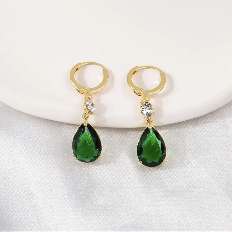 A pair of green geometric teardrop-shaped alloy earrings on a plain background.