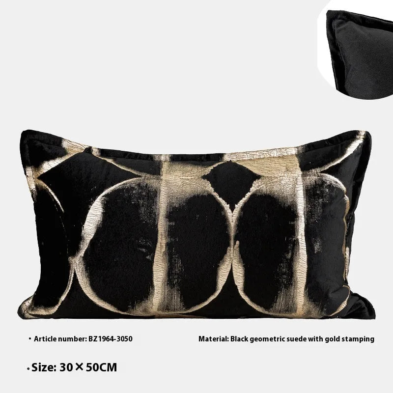 Black and gold abstract patterned square cushion on a grey sofa