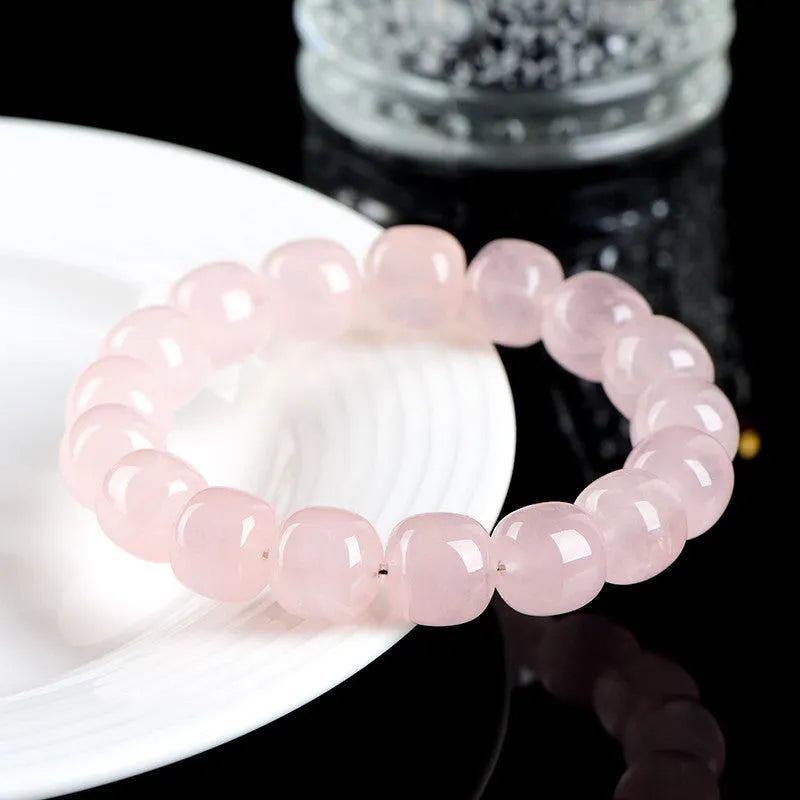 Close-up of a pink crystal barrel bead bracelet with 11-12mm beads on a wrist.