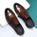 Men's black brogue leather shoes with decorative perforations and lace-up front.