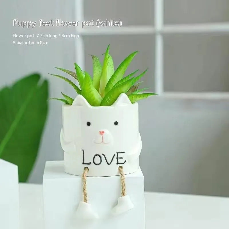 Ceramic cartoon-style hanging foot flowerpot for succulent plants on a desktop.