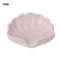 White and pink plastic shell-shaped soap dish for bathroom countertops.