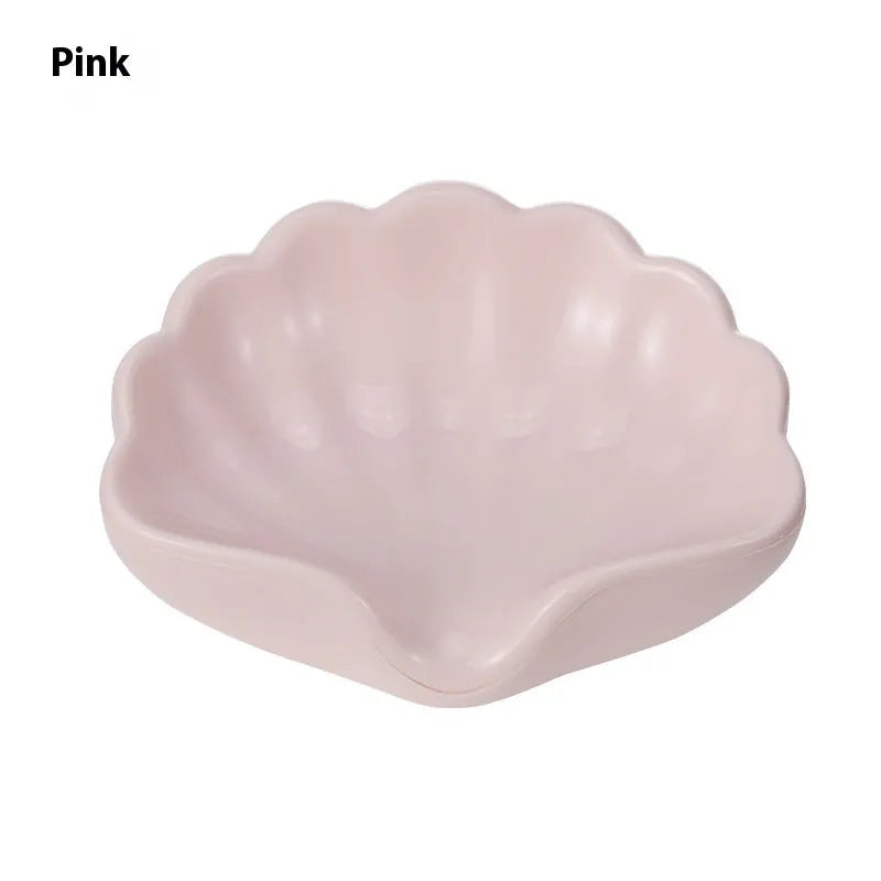 White and pink plastic shell-shaped soap dish for bathroom countertops.