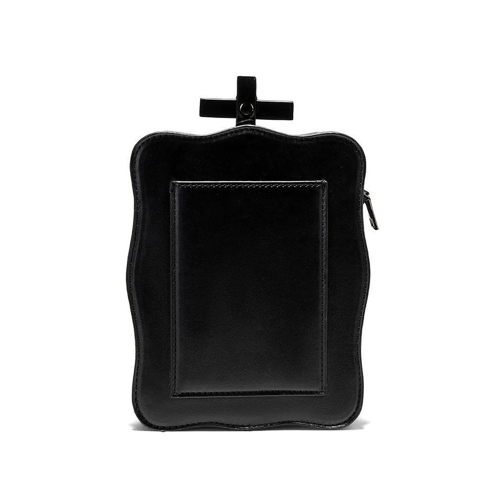 Black mini square crossbody bag with embossed skull design, metal chain strap, rivets, and contrast stitching.