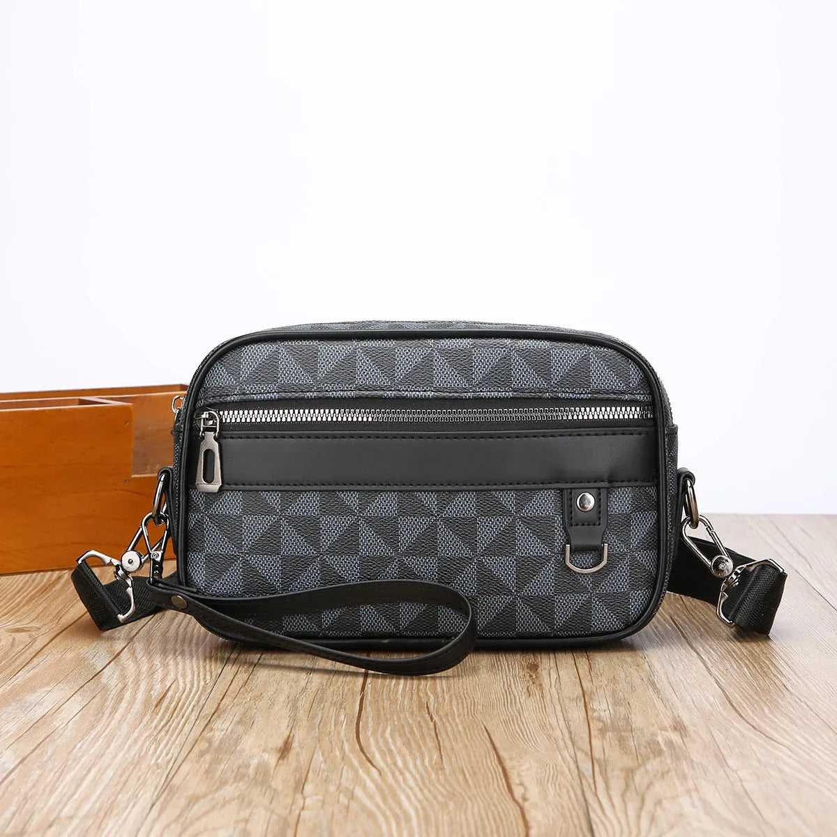 Men's black geometric pattern messenger bag shown in horizontal carrying position with shoulder strap
