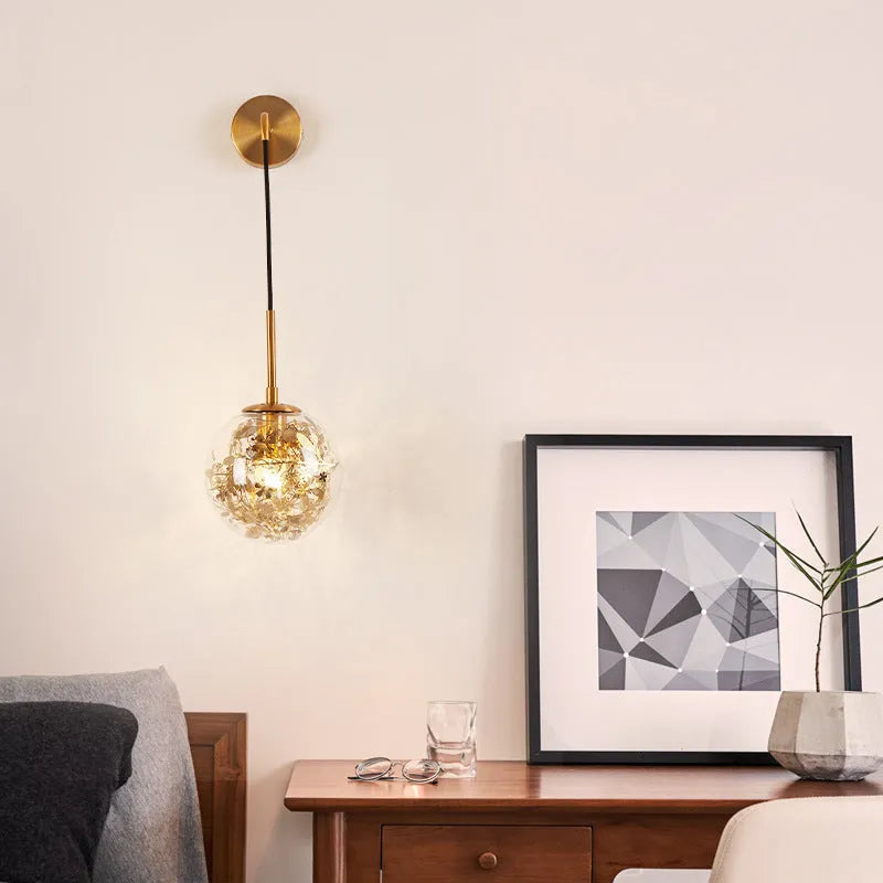 Small modern glass wall lamp in golden flower or silver flower finish for bedside lighting.