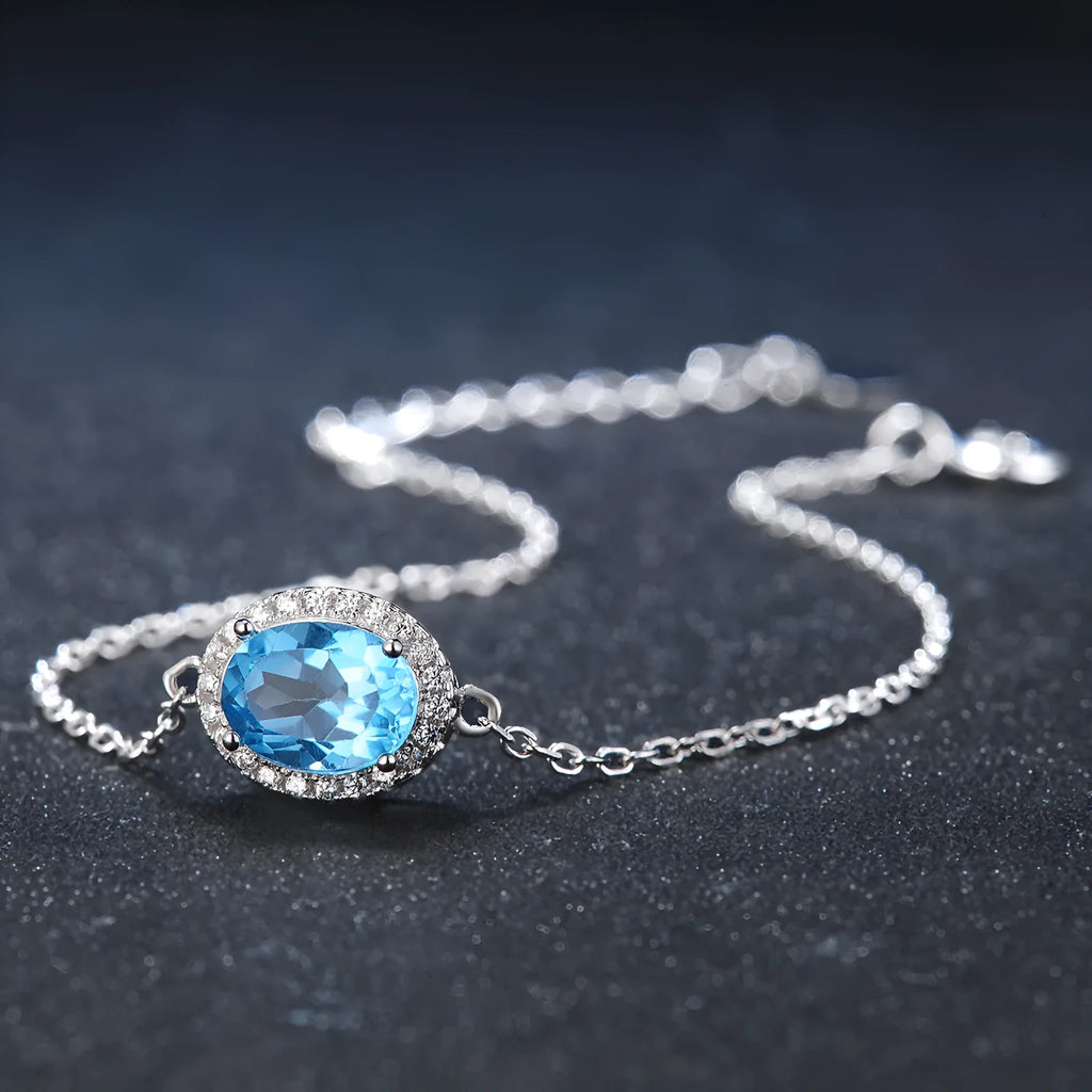 925 sterling silver jewellery set with blue topaz gems in geometric design including earrings, ring, necklace and pendant