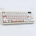 Close-up of a rounded mechanical keyboard key cap with a colourful cartoon dessert cat character print.