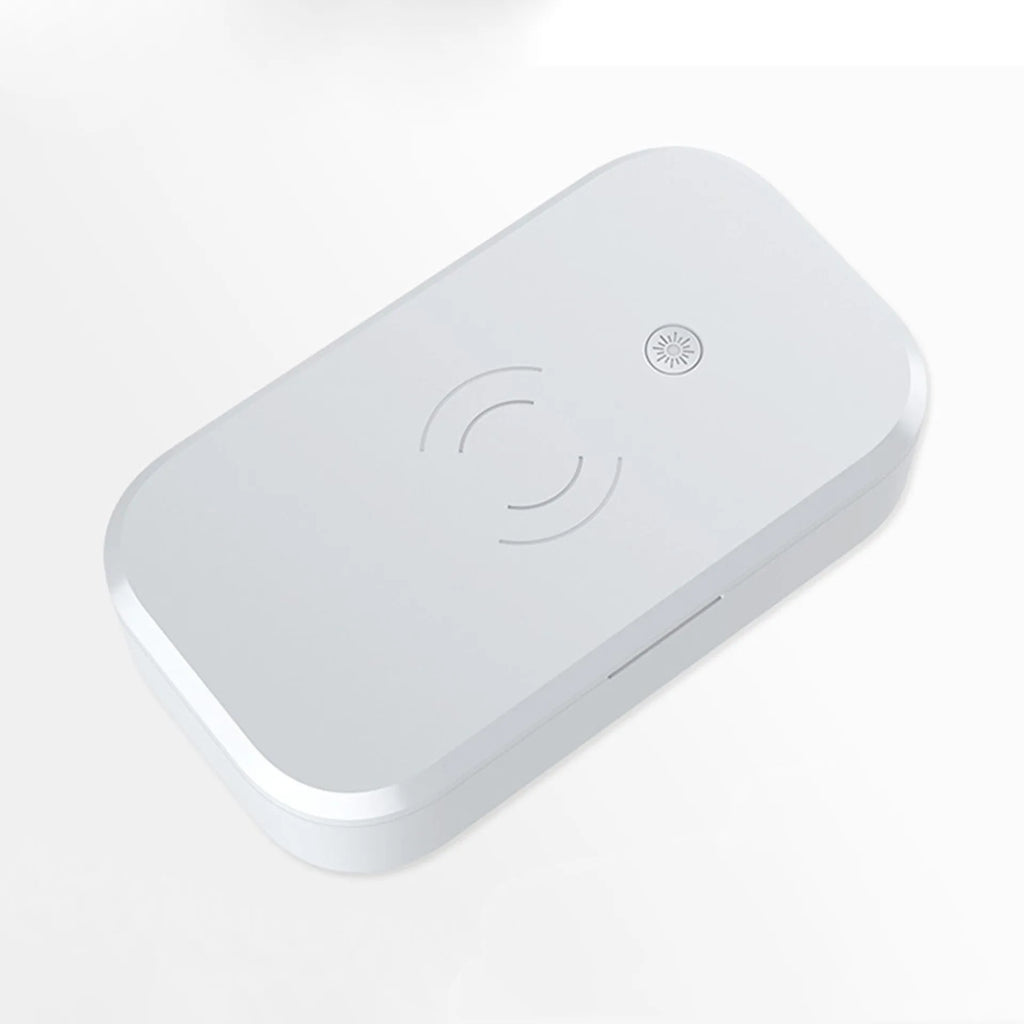 White UV disinfection box with wireless charging pad for phones and nail tools.