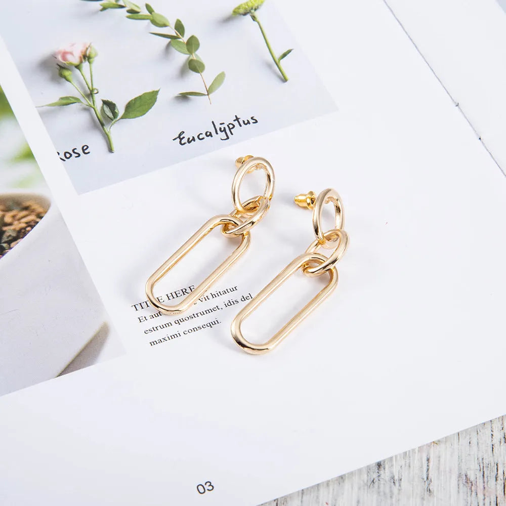 Geometric sterling silver needle colour hoop drop earrings with ring and line design on a white background.