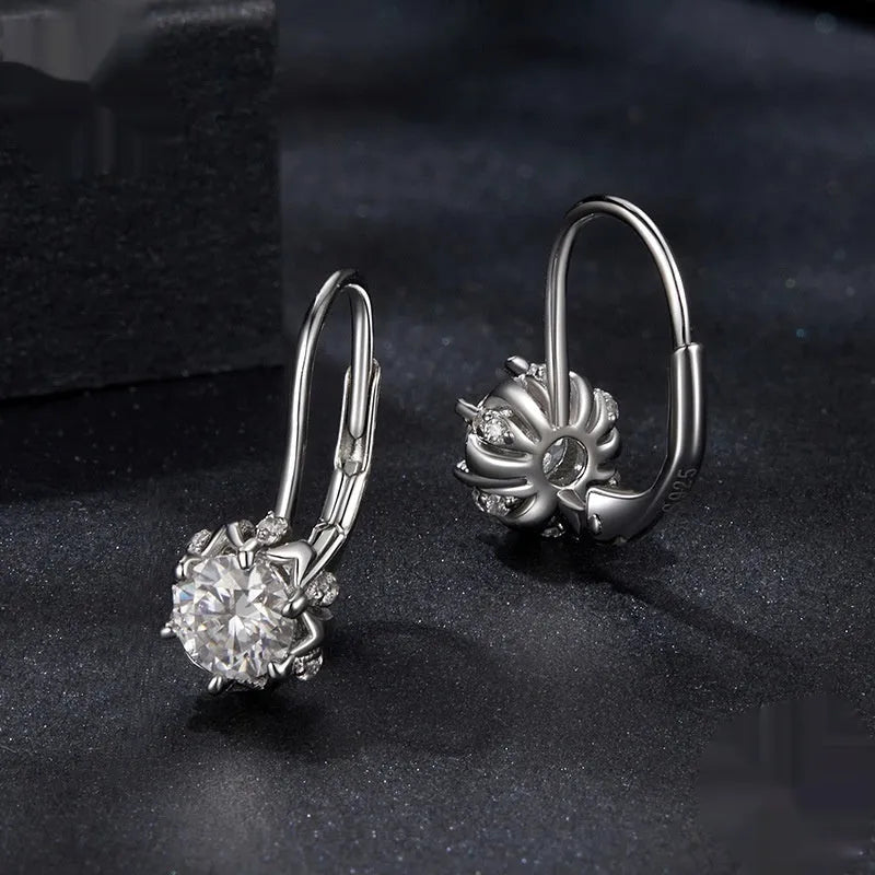 Close-up of a sterling silver flower bud ear clip with a white gold plated finish and a central moissanite stone.