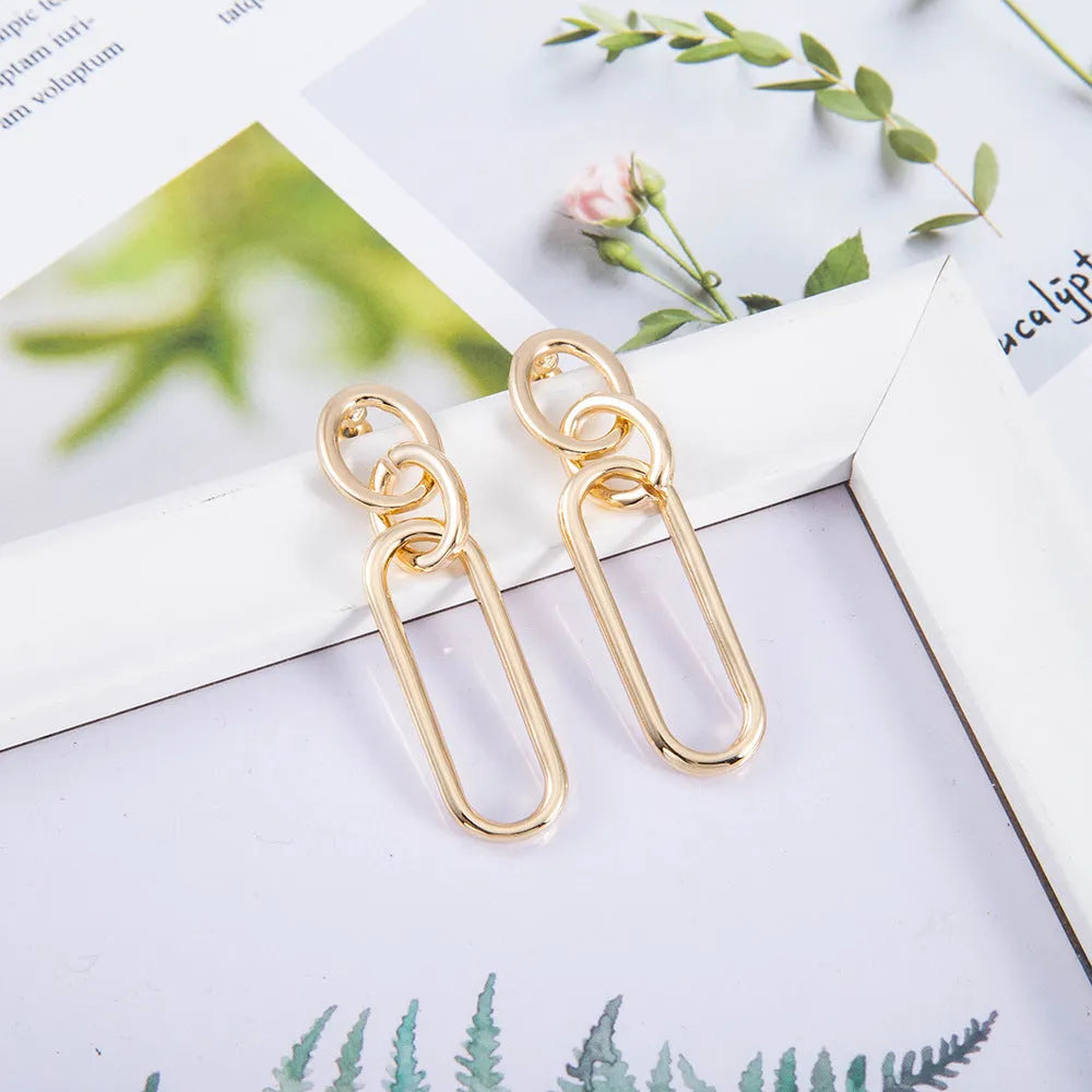 Geometric sterling silver needle colour hoop drop earrings with ring and line design on a white background.