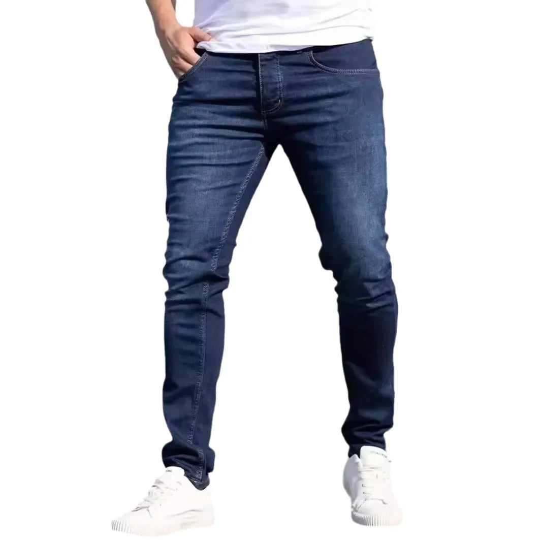 Men's dark blue slim-fit casual jeans with skinny leg and zip fly.