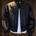 Men's black PU leather jacket with litchi grain texture, showing extended length and tight fit.