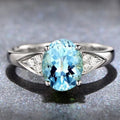 Women's court style zircon ring with heart pattern and blue stone.