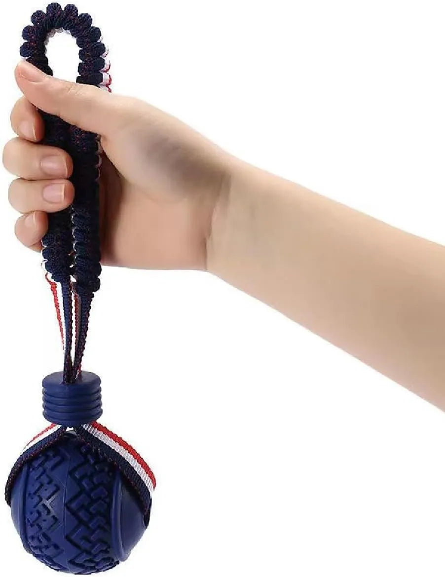 Red rubber dog ball with rope attachment for tug of war and teeth cleaning