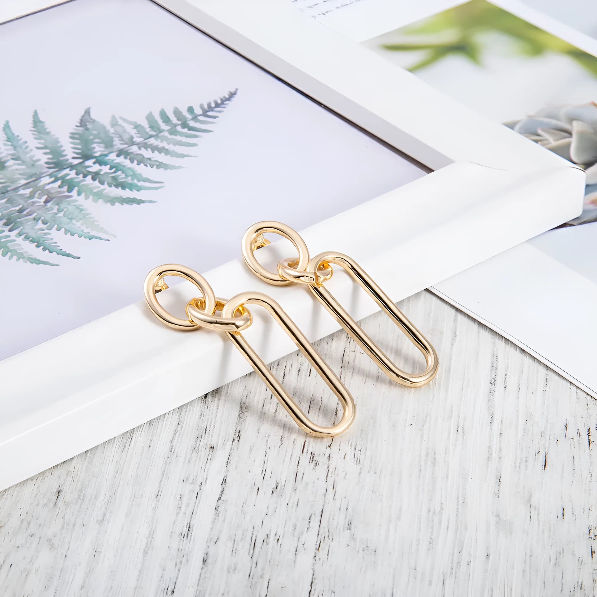 Geometric sterling silver needle colour hoop drop earrings with ring and line design on a white background.