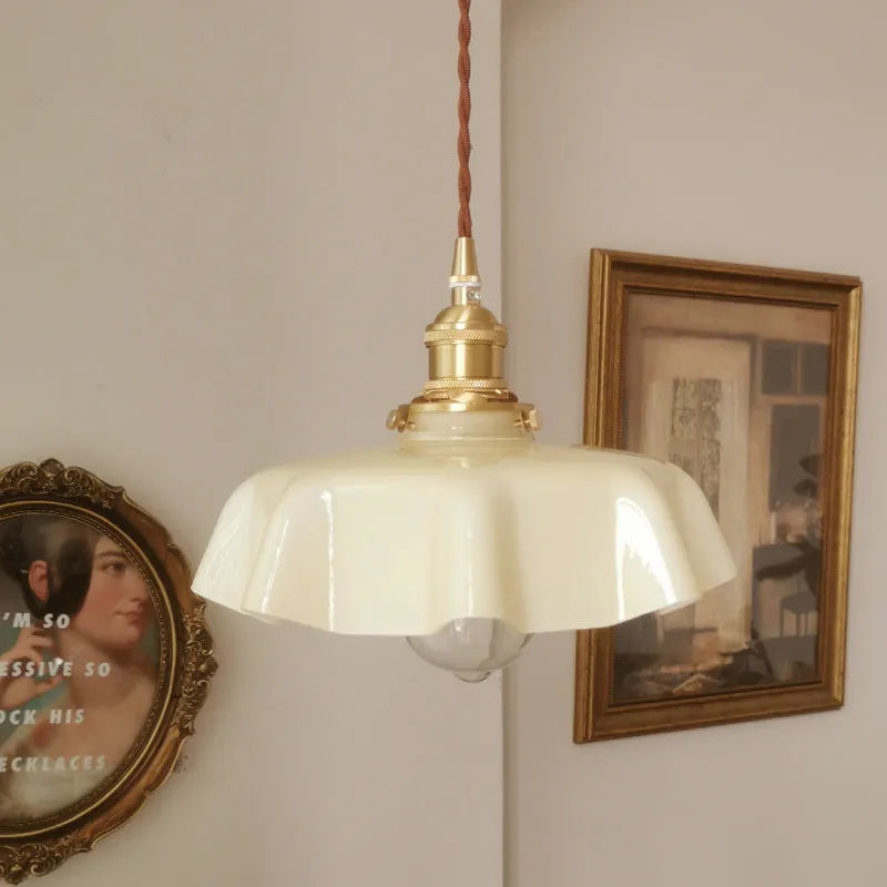 Medieval style brass flower bud chandelier with glass body, shown with adjustable height chain.