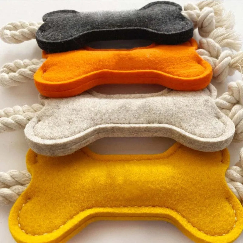 Bone-shaped felt dog chew toy with rope knot interior in blue, shown next to a tape measure indicating 16 cm length.