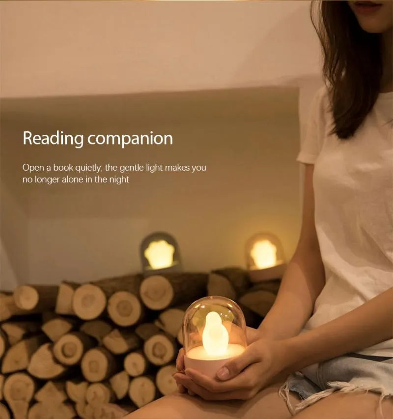 Grey and pink cat paw shaped USB rechargeable night light with adjustable brightness on a desk.