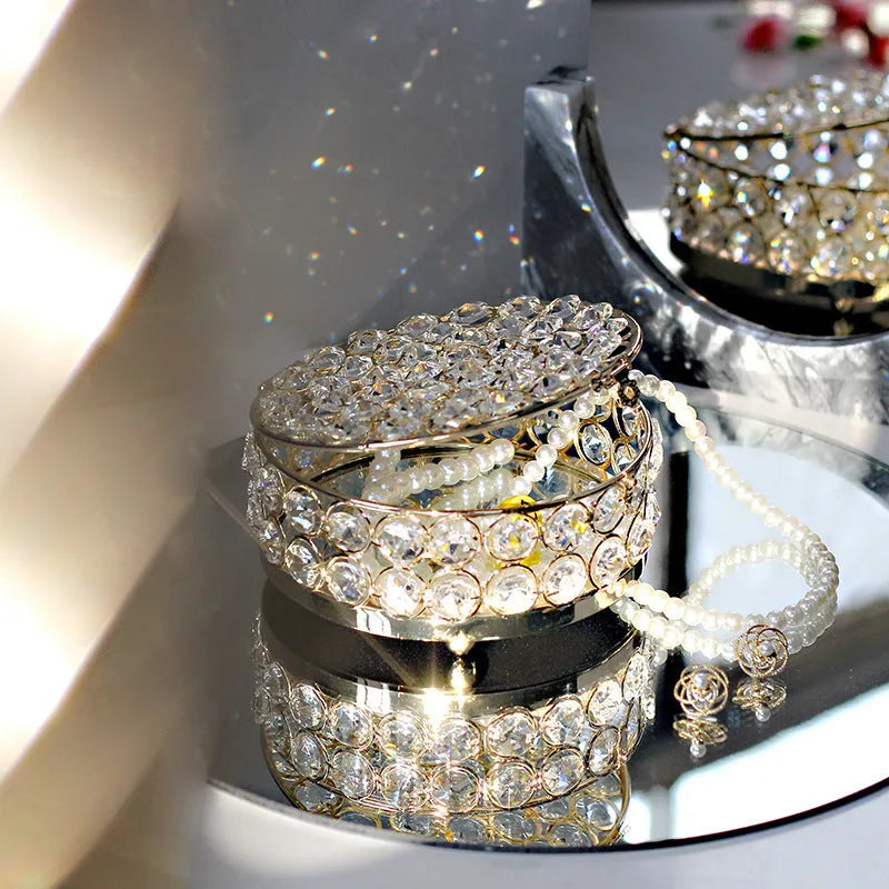 French gold metal jewellery box with a transparent crystal glass lid on a table.