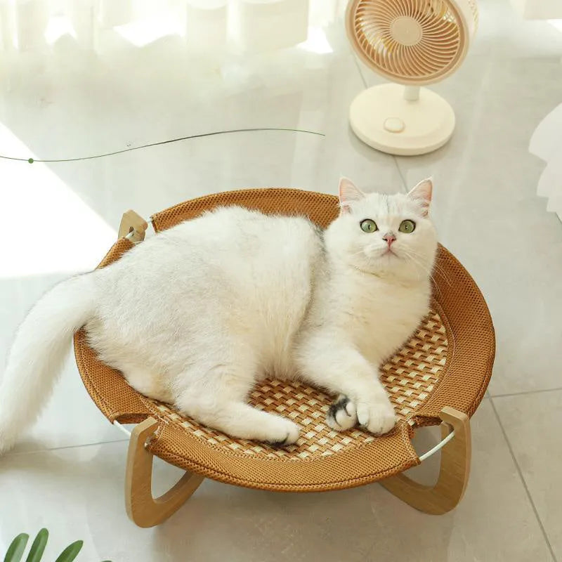 Brown woven rattan pet hammock bed for cats and small dogs on a white floor