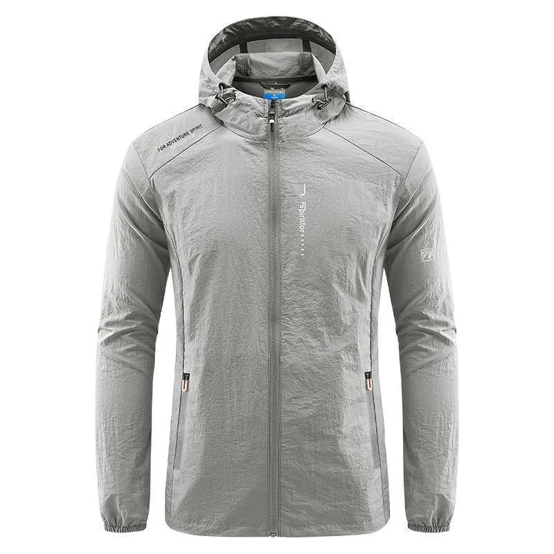 Man wearing a lightweight grey hooded nylon summer jacket outdoors.