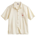 Light apricot men's shirt with bamboo pattern and Cuban collar laid flat.