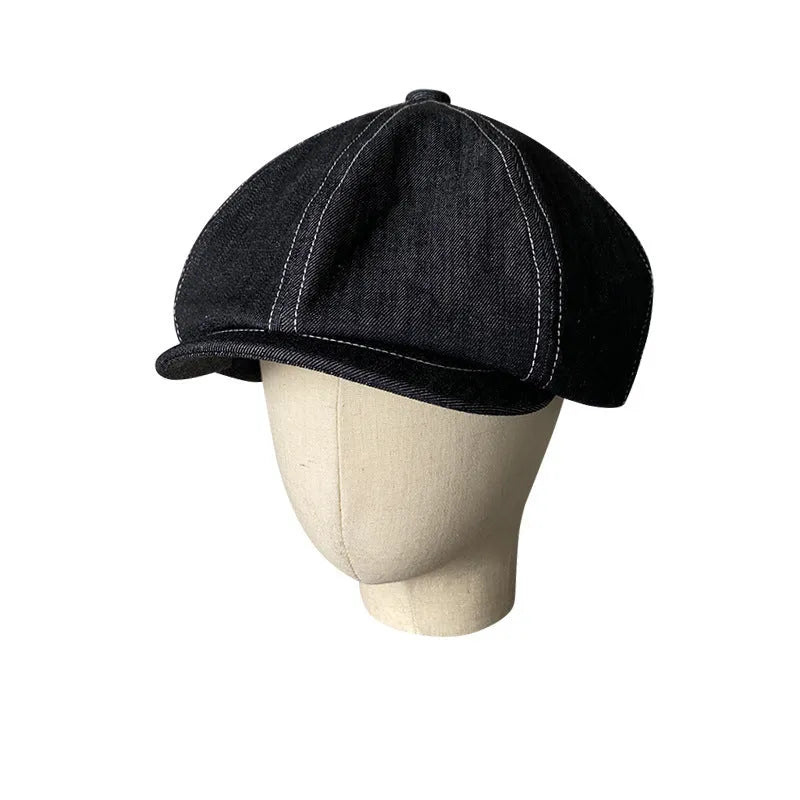 Black cotton beret with an octagonal cap style on a neutral background.