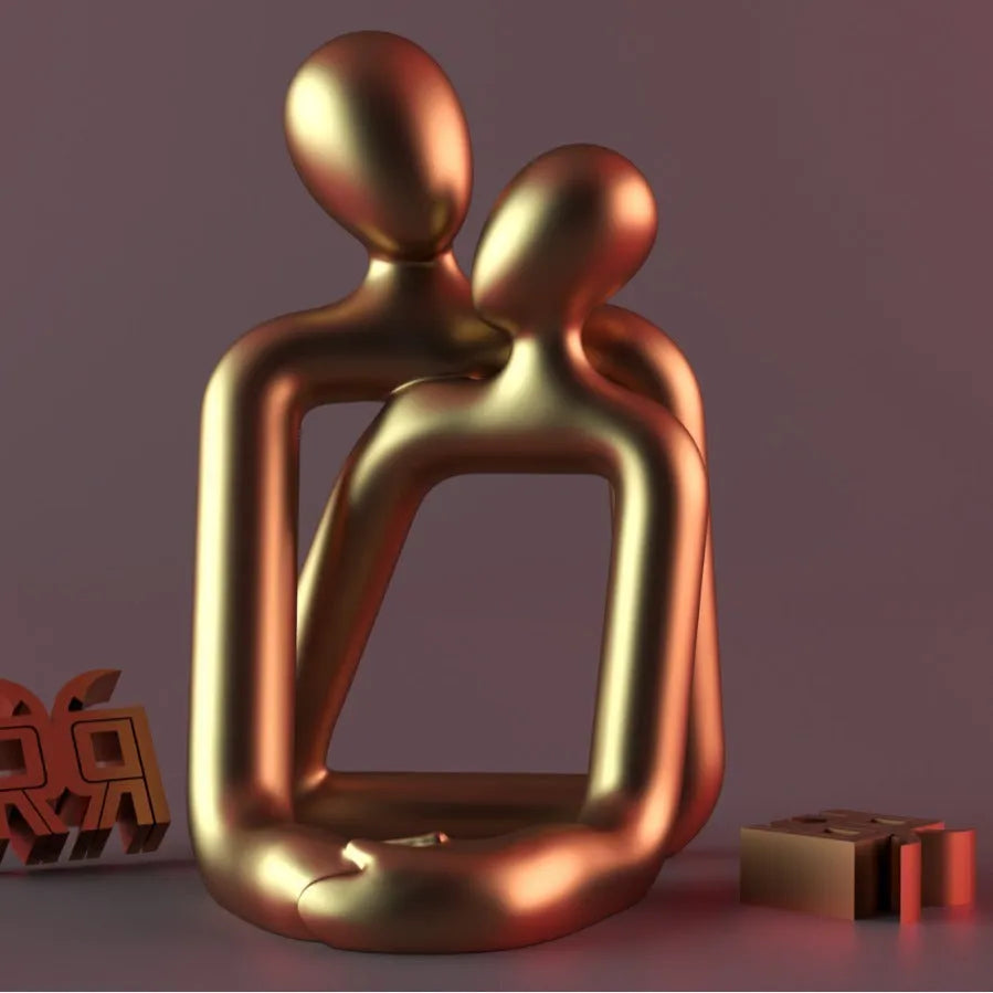 Modern couple resin statue in milky white or gold on a wooden surface.