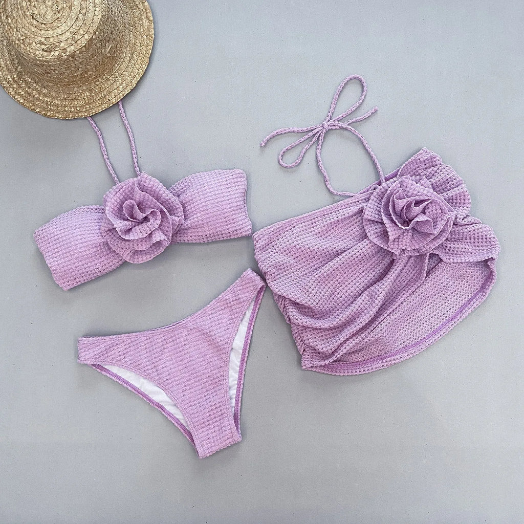 Women's purple and white 3D flower split three-piece bikini set with bra, briefs, and skirt.