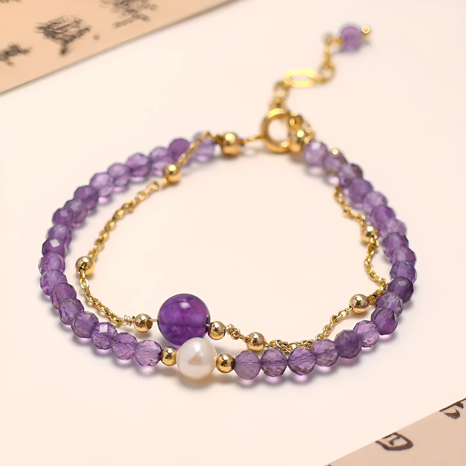 Close-up of a Chinese style women's bracelet with diamond-shaped amethyst crystal beads and an electroplated finish.