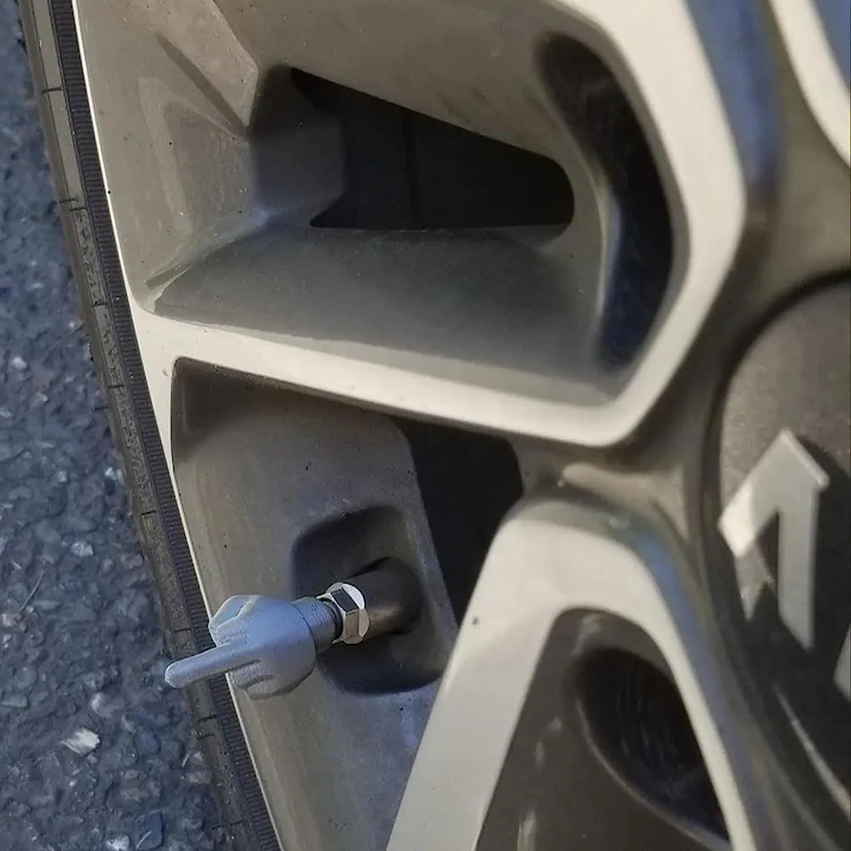 Four latex car tyre valve dust caps, two black and two skin colour, arranged together.