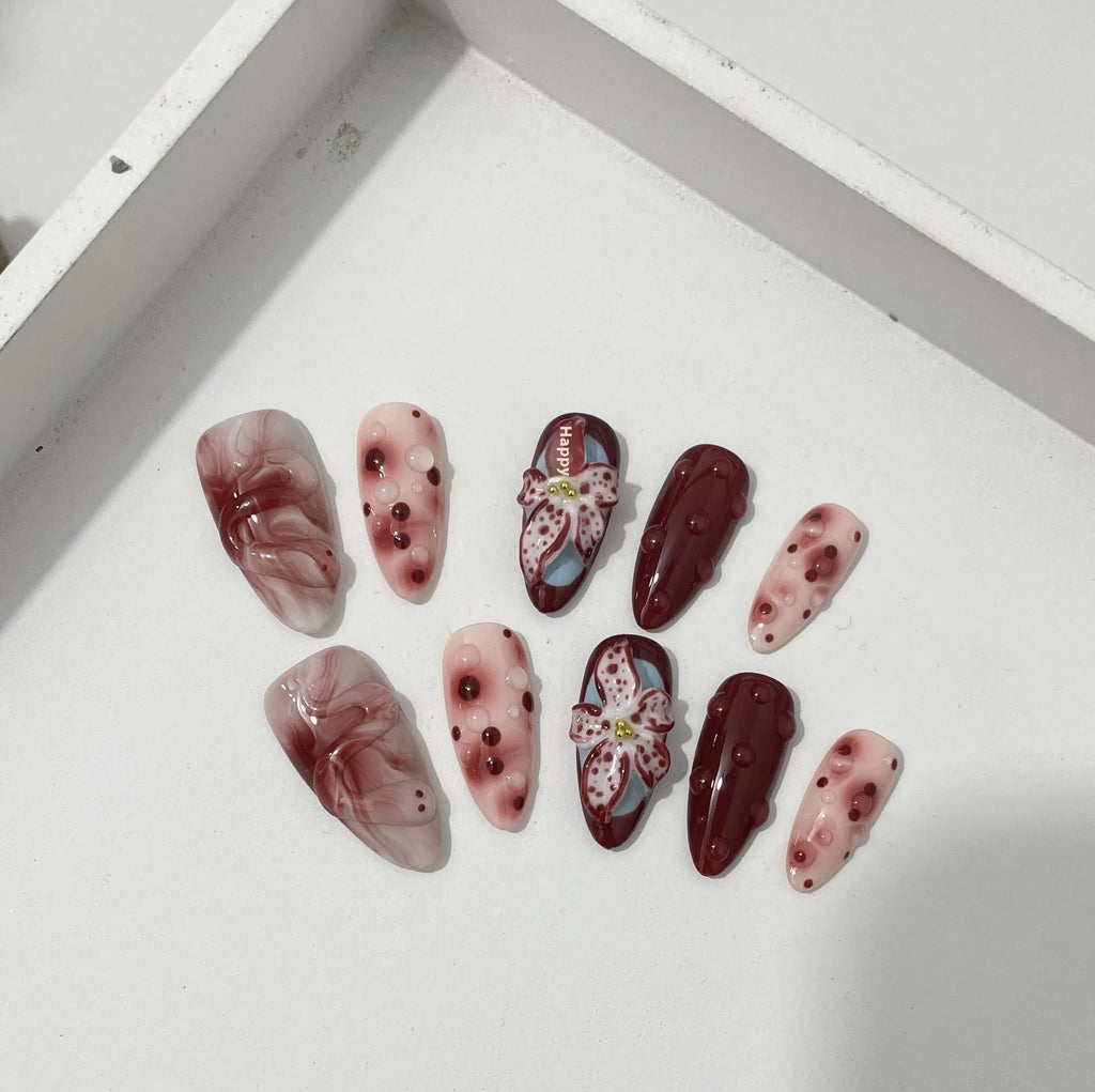 Almond colour artificial nails with 3D carved floral designs including roses and tulips