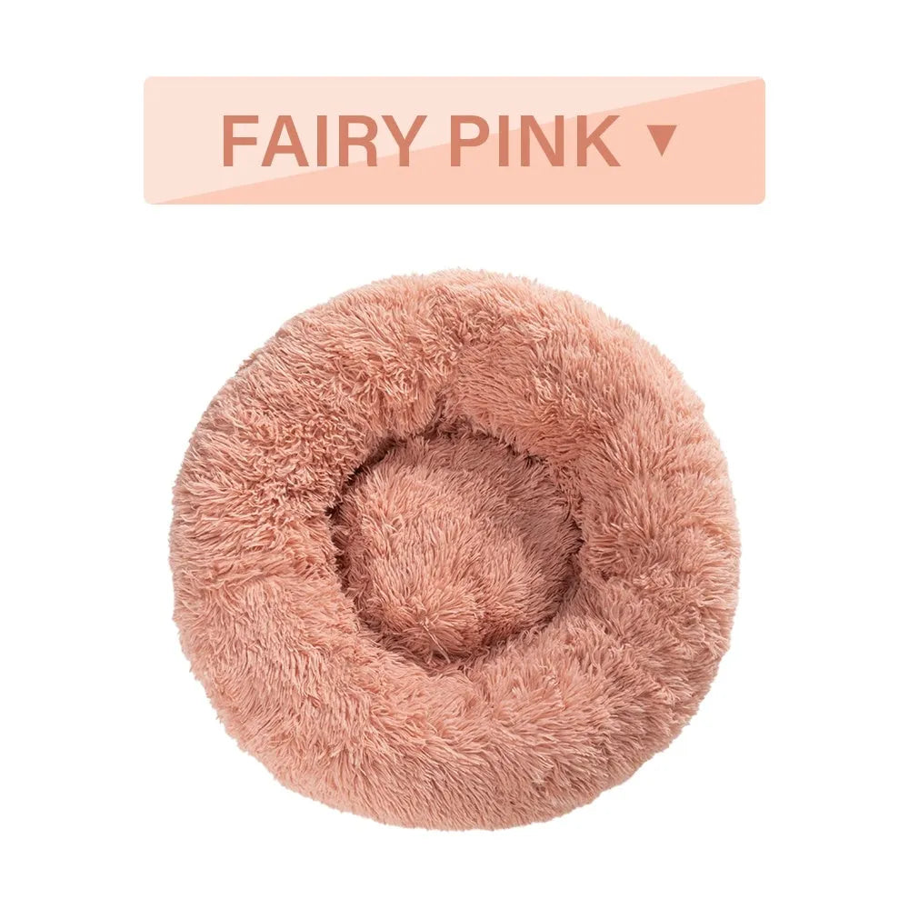 A round donut-shaped dog bed with a raised plush rim, shown in a light grey colour.