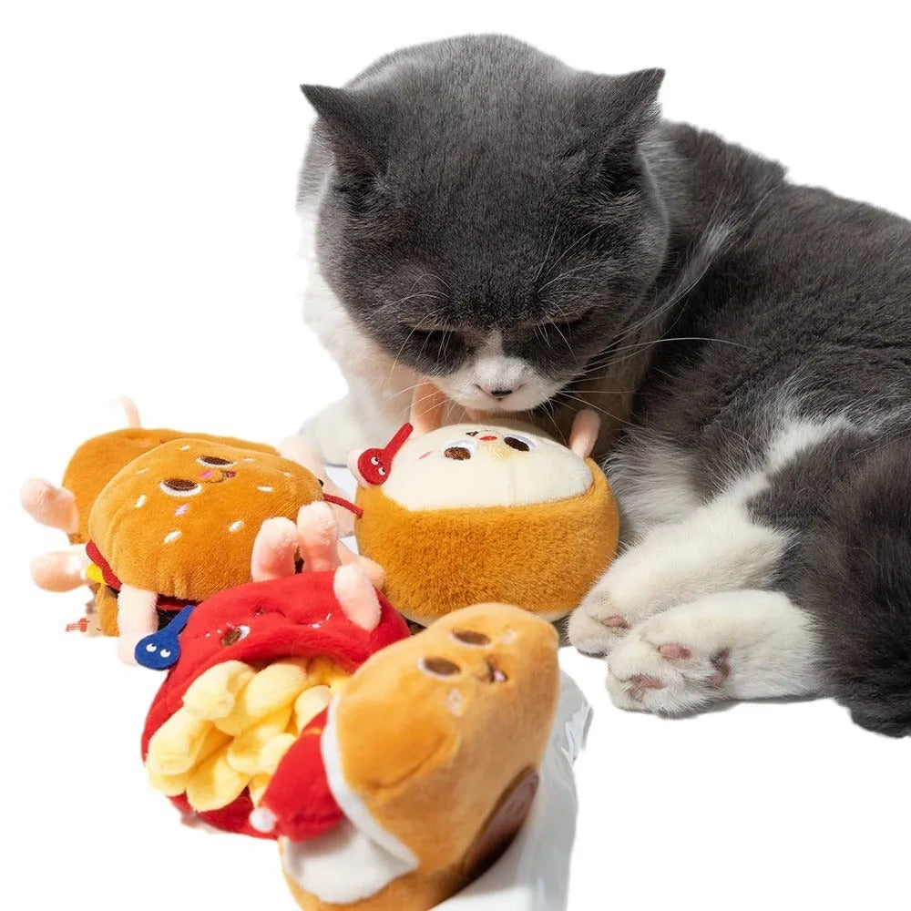 Set of four soft fabric cat chew toys shaped like a hamburger, chicken leg, fries, and hot dog on a plain background.