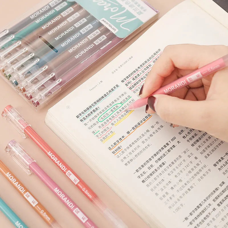 Set of nine retro style gel pens with 0.5mm needle tips in plastic casings on a notebook