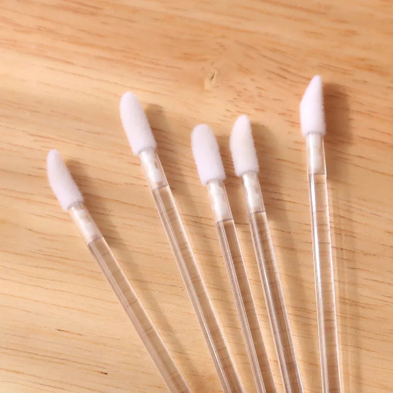 Pack of disposable lip brushes with flocked heads and coloured handles, shown in quantities from 200 to 500 pieces.