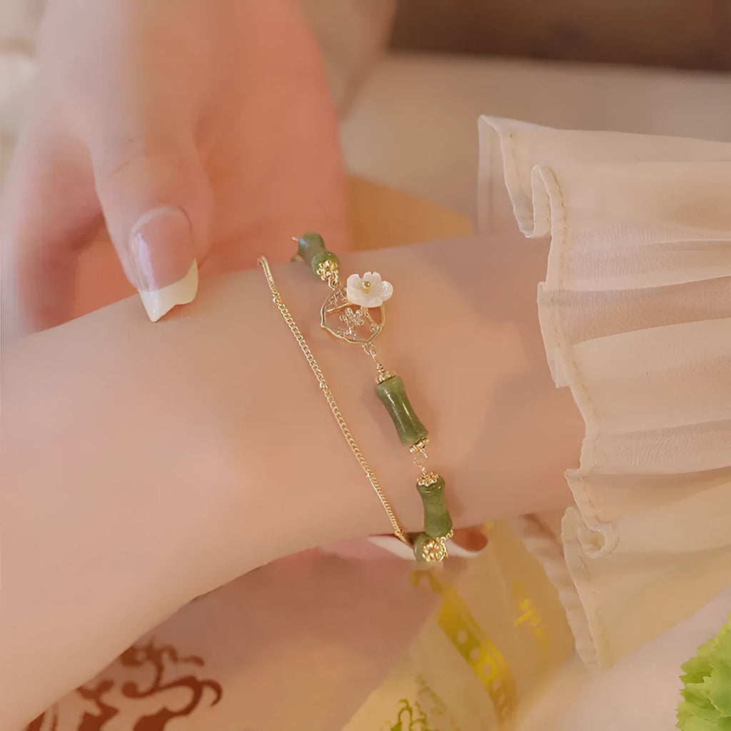 Handcrafted natural olivine bracelet with double layer design and twin Bells of Ireland charms.