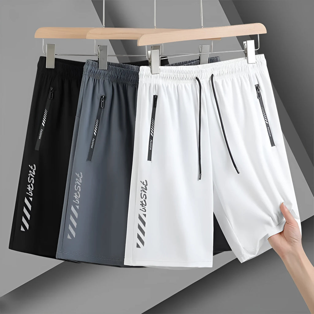 Man wearing loose fit black nylon sports shorts with an elastic waistband.