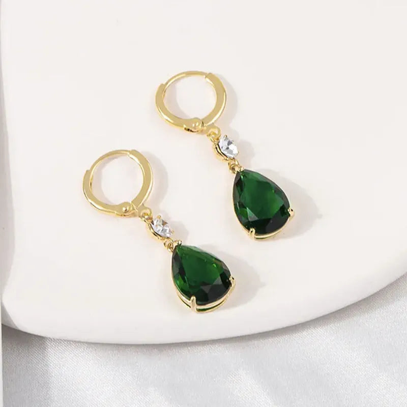 A pair of green geometric teardrop-shaped alloy earrings on a plain background.