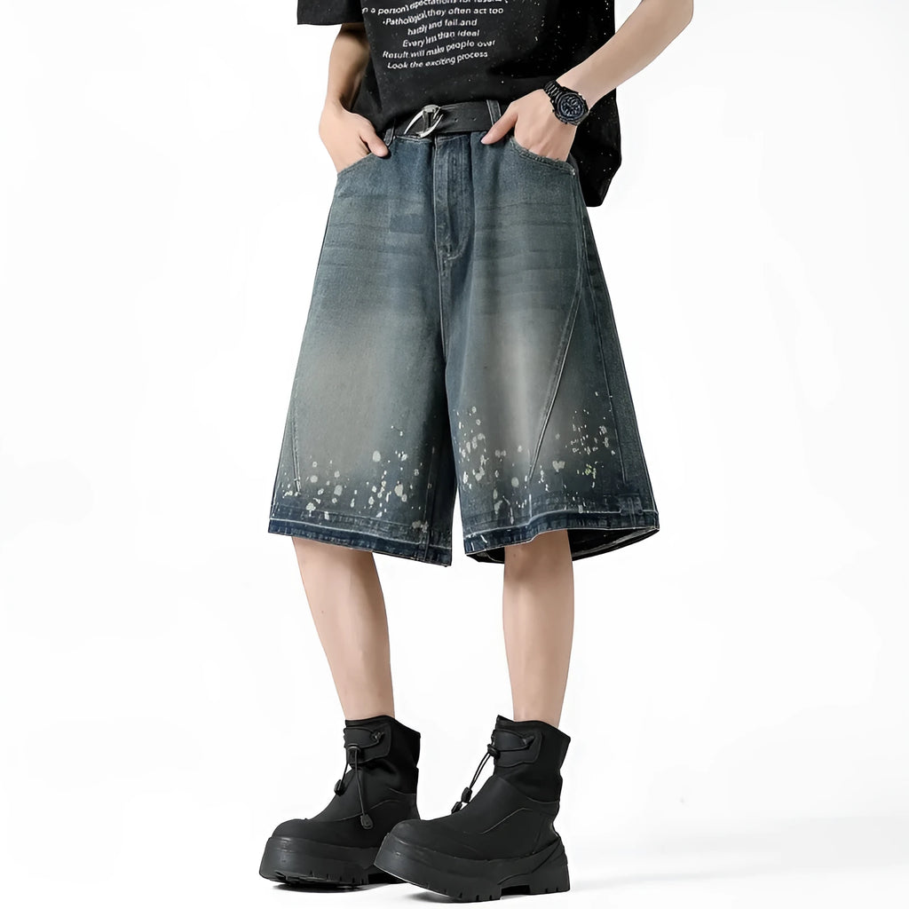 Man wearing retro blue washed denim shorts with ripped details and a straight-leg cut.