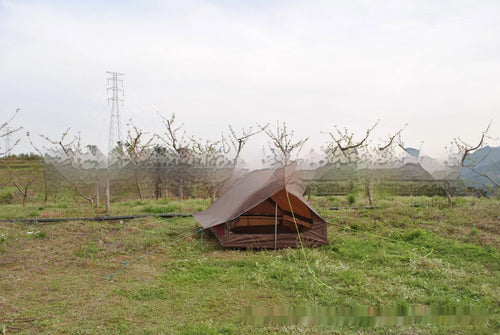 Brown and white pole-free A-line cabin tent set up with hiking canes, showing spacious interior