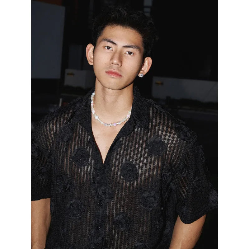 Man wearing a beige loose-fit short sleeve shirt with a textured three-dimensional floral print pattern.