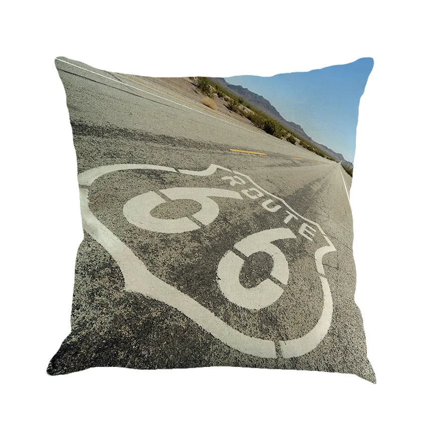 Route 66 landscape printed linen blend cushion cover on a sofa, showing blue and beige colour option.