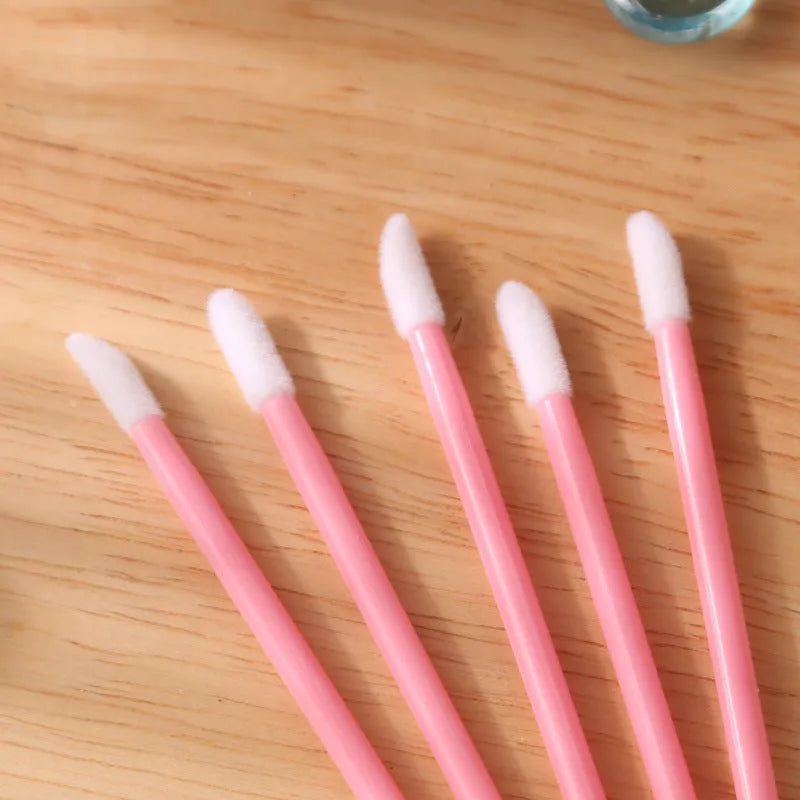 Pack of disposable lip brushes with flocked heads and coloured handles, shown in quantities from 200 to 500 pieces.