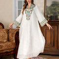 White women's Dubai Arabic robe with long sleeves and floor-length skirt.