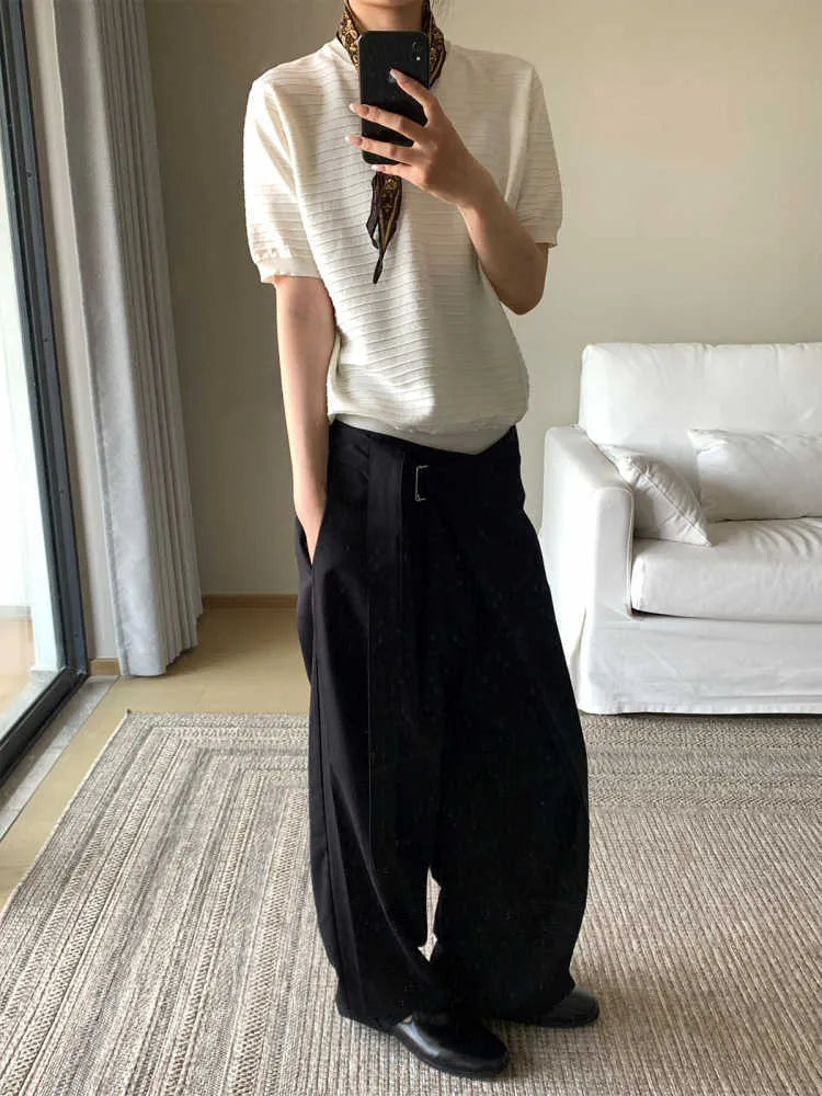 Black loose-fit straight-leg trousers with a single pleat and adjustable mid waist on a hanger.