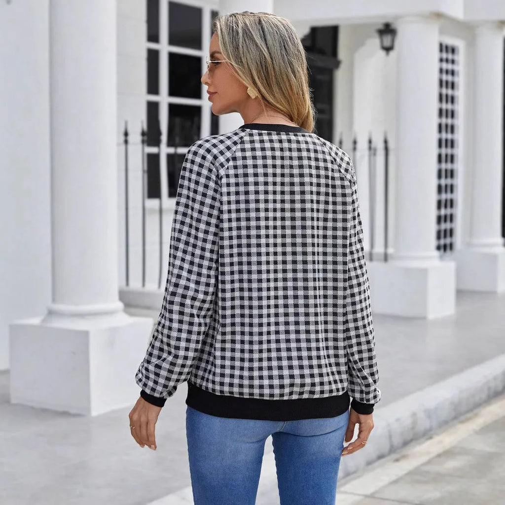 Black polyester pullover sweater with a plaid printed pattern and long sleeves.