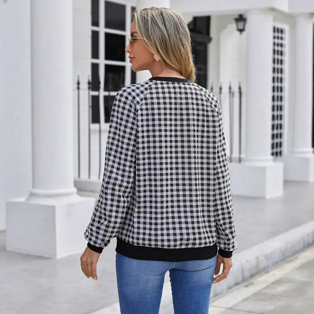 Black polyester pullover sweater with a plaid printed pattern and long sleeves.